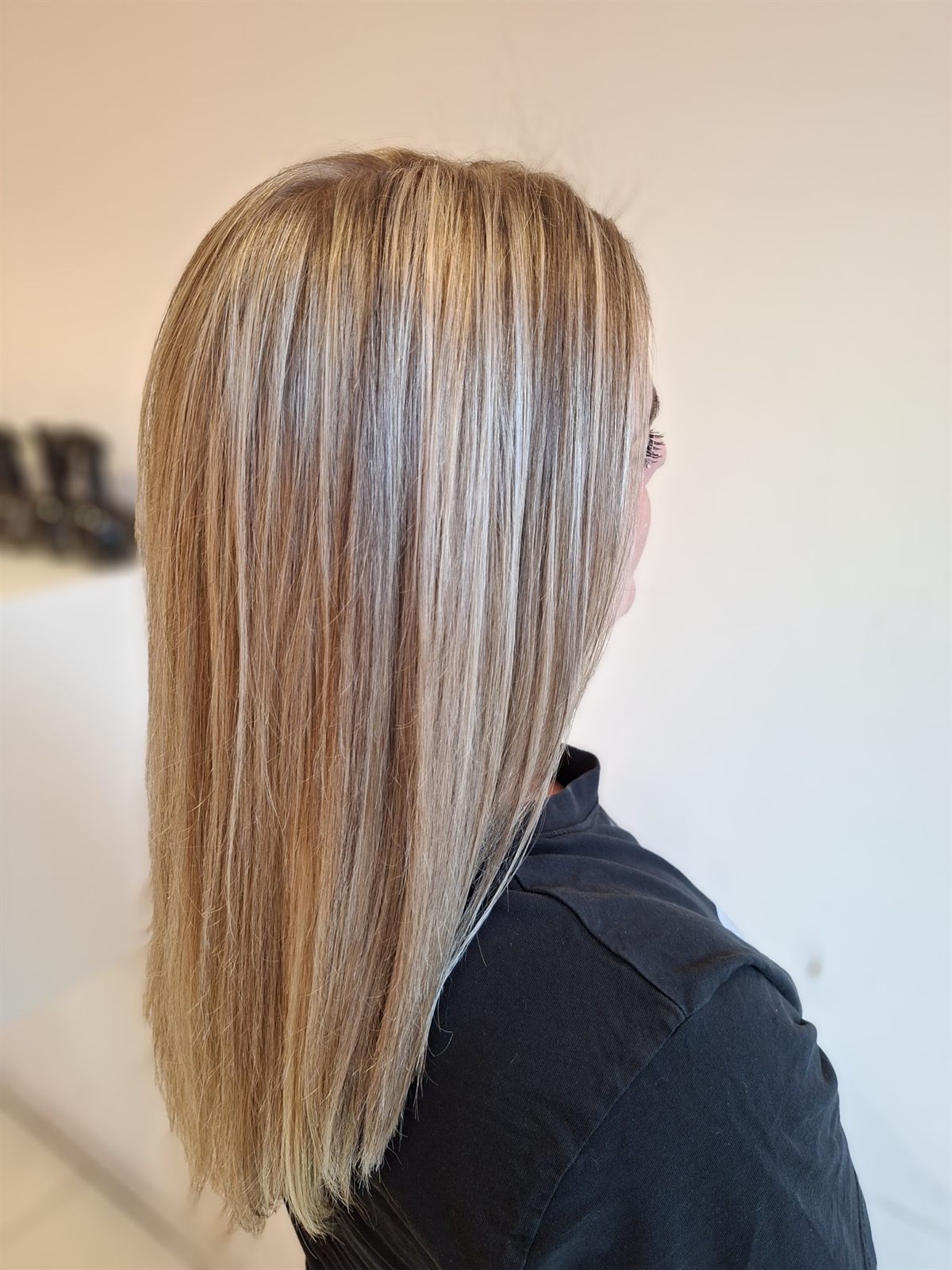 Glad, schouderlang haar met lichte blonde accenten, schuin van achteren gezien